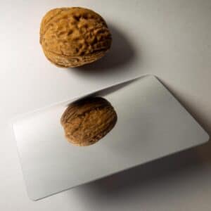 RFID-Chipkarte mit Spiegelfläche neben einer Baumnuss